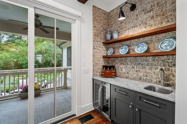 bar featuring light stone counters, ceiling fan, sink, dark hardwood / wood-style floors, and wine cooler