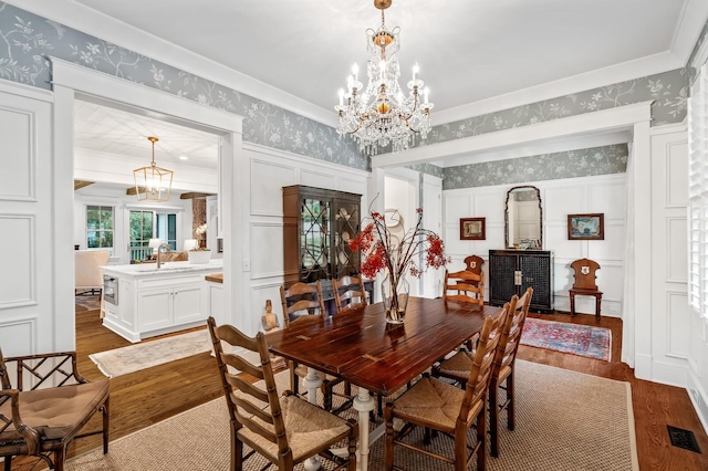 dining area with an inviting chandelier, dark wood-type flooring, and sink