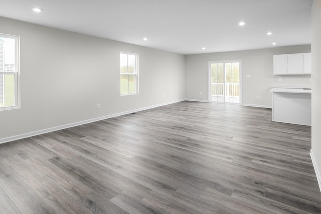 unfurnished living room with hardwood / wood-style floors and a healthy amount of sunlight