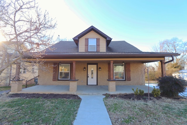 view of front facade featuring covered porch and a front lawn