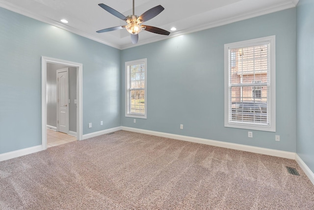 spare room featuring ceiling fan, crown molding, and light colored carpet