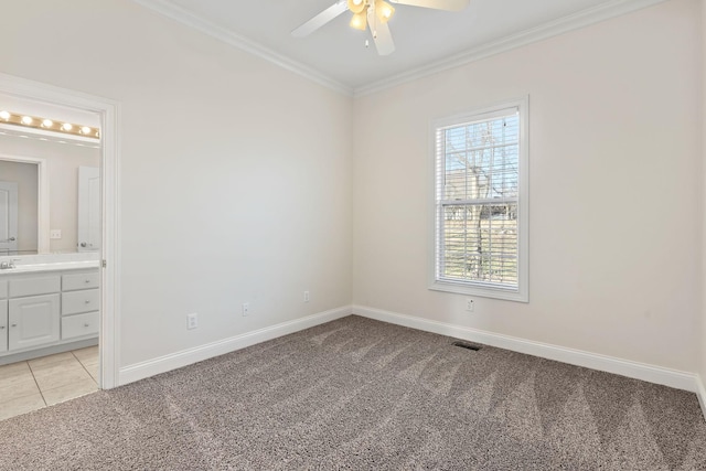 spare room featuring ceiling fan, ornamental molding, and light carpet