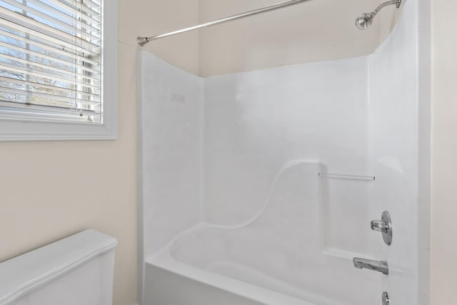 bathroom featuring shower / bathing tub combination and toilet