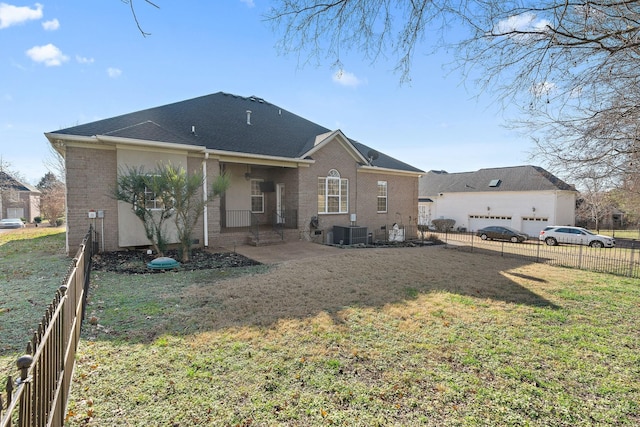 back of property featuring a patio, central air condition unit, a garage, and a lawn