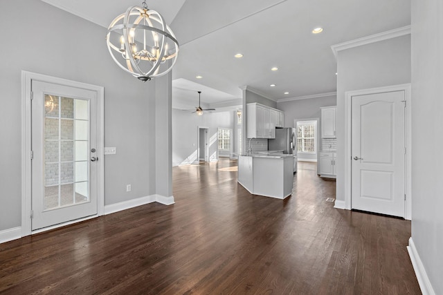 kitchen with dark hardwood / wood-style floors, pendant lighting, white cabinets, ceiling fan with notable chandelier, and ornamental molding