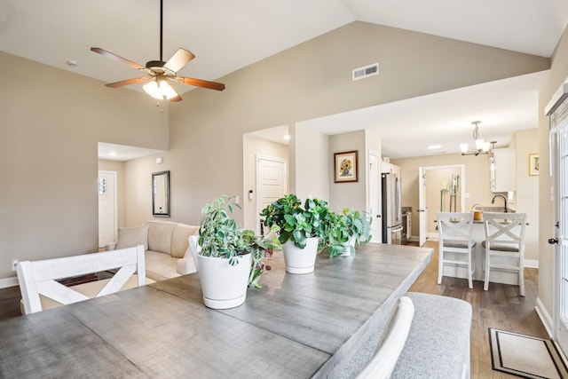 dining room featuring sink, high vaulted ceiling, ceiling fan with notable chandelier, and hardwood / wood-style flooring