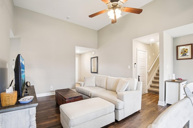 living room featuring ceiling fan, dark hardwood / wood-style flooring, and a towering ceiling