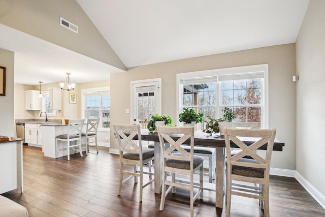 dining space featuring a notable chandelier, dark hardwood / wood-style flooring, lofted ceiling, and sink