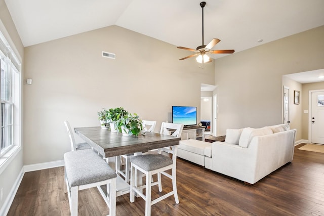 dining room with dark hardwood / wood-style flooring, vaulted ceiling, and ceiling fan