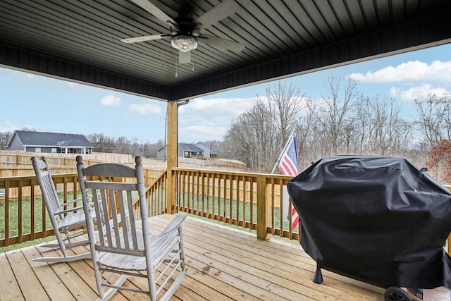 wooden terrace featuring ceiling fan and a grill