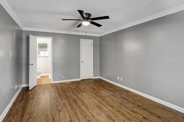 unfurnished bedroom featuring wood-type flooring, a textured ceiling, ensuite bathroom, and ceiling fan