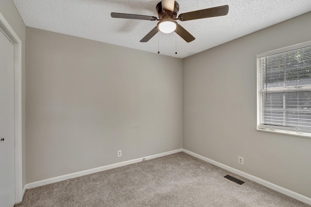 carpeted empty room featuring ceiling fan and a textured ceiling