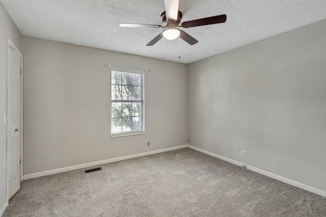 carpeted spare room with a textured ceiling and ceiling fan