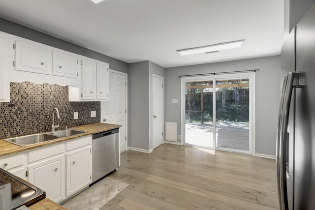 kitchen featuring sink, white cabinets, stainless steel appliances, and light hardwood / wood-style floors