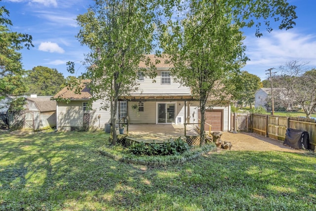 back of house with a lawn, a wooden deck, and a garage