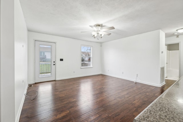 spare room featuring a textured ceiling, ceiling fan, and dark hardwood / wood-style floors