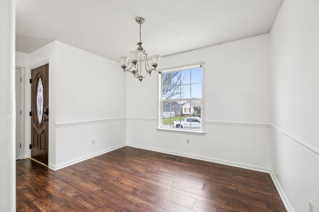 unfurnished room featuring dark wood-type flooring and a chandelier