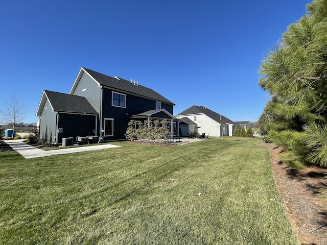 rear view of house featuring a lawn and a patio