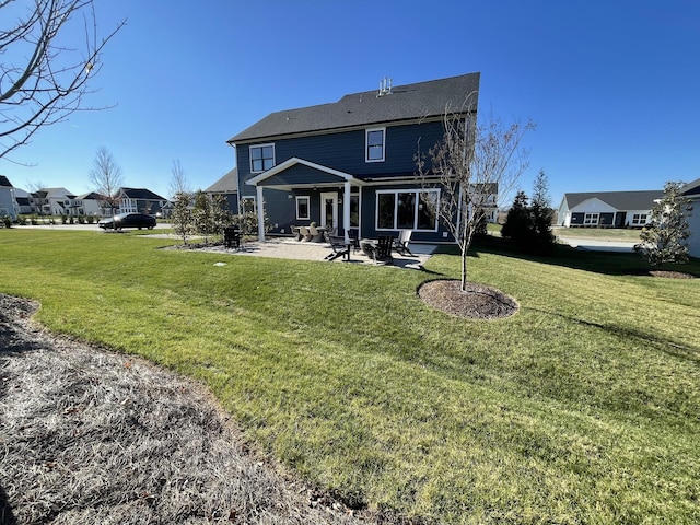 rear view of house with a yard and a patio