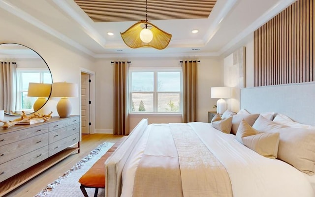 bedroom with a raised ceiling and light hardwood / wood-style floors