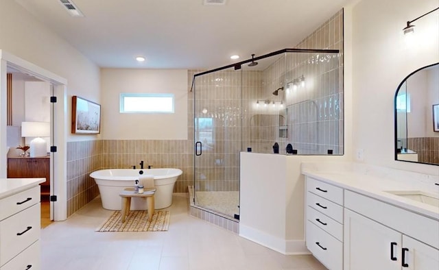 bathroom featuring shower with separate bathtub, tile walls, tile patterned floors, and vanity