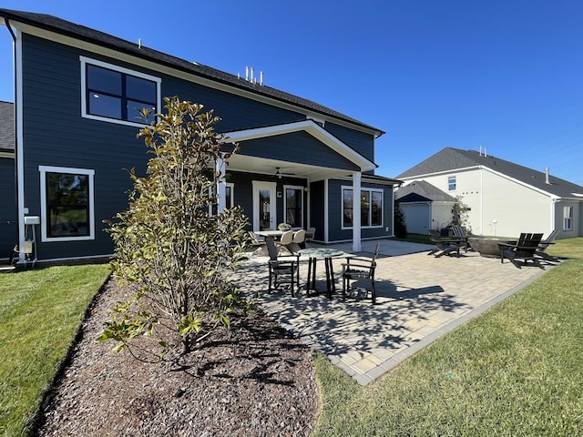 back of house featuring ceiling fan, a patio area, and a lawn