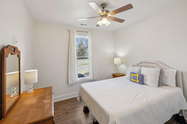 bedroom featuring a ceiling fan, visible vents, wood finished floors, and baseboards