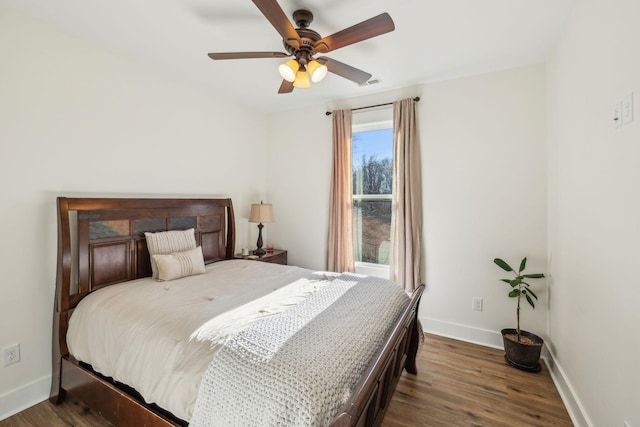 bedroom featuring visible vents, baseboards, wood finished floors, and a ceiling fan