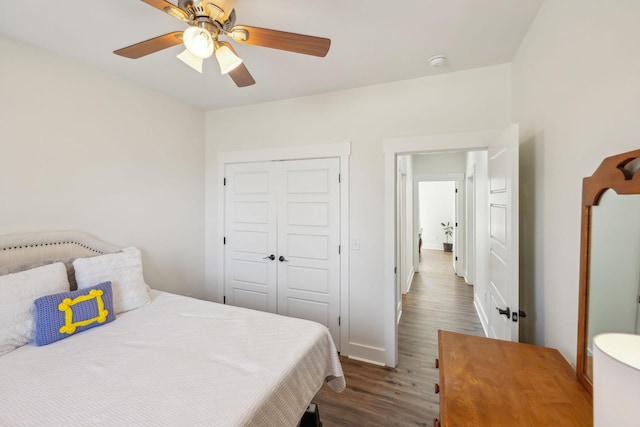 bedroom with dark wood finished floors, baseboards, a closet, and ceiling fan