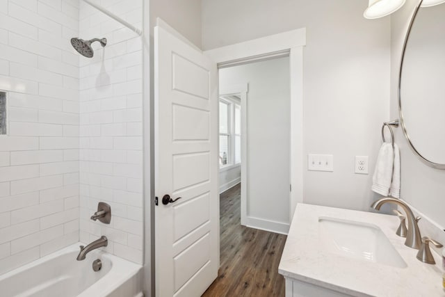 full bath featuring vanity, bathing tub / shower combination, wood finished floors, and baseboards