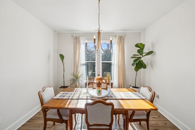 dining room with baseboards, an inviting chandelier, and dark wood finished floors