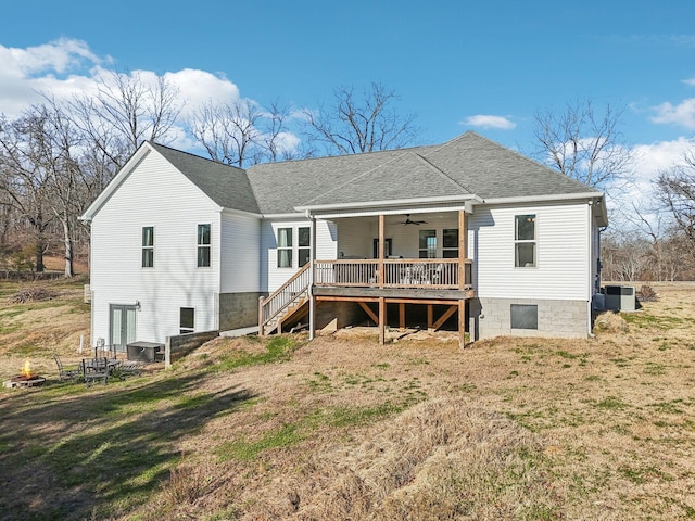 back of property with stairway, a ceiling fan, central AC, a shingled roof, and a lawn