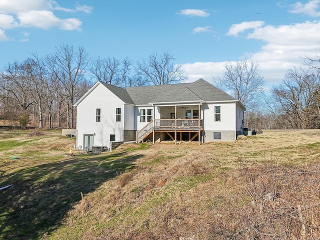 back of property featuring a lawn, a deck, stairway, a shingled roof, and ceiling fan