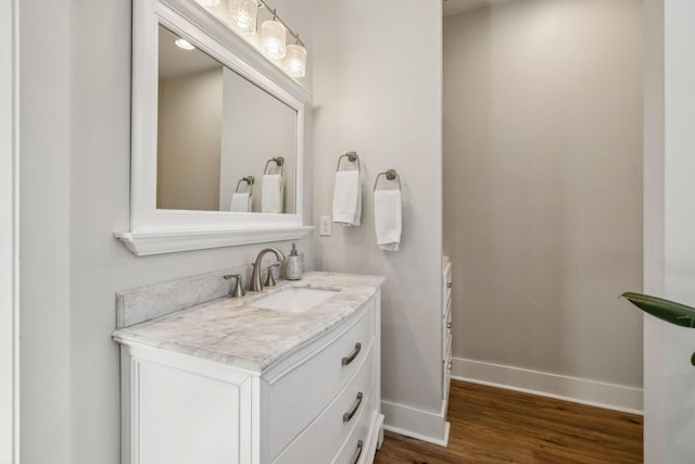 bathroom featuring vanity, wood finished floors, and baseboards