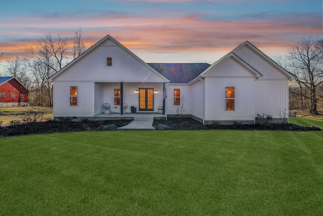 modern farmhouse style home with a porch and a yard