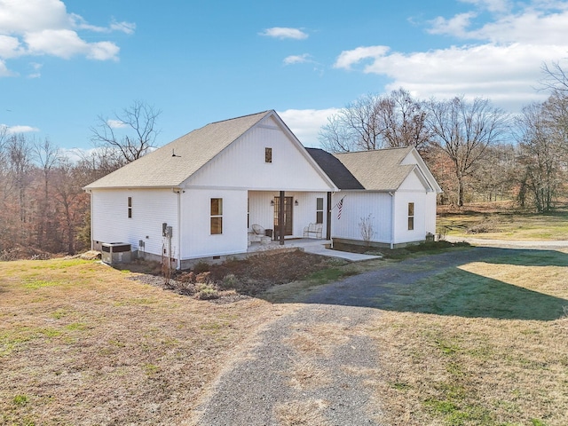 modern inspired farmhouse with covered porch, central AC unit, and a front lawn