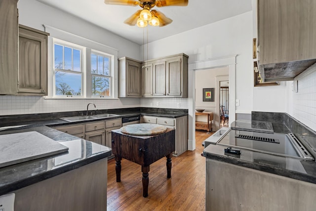 kitchen with dishwasher, sink, dark hardwood / wood-style floors, ceiling fan, and decorative backsplash