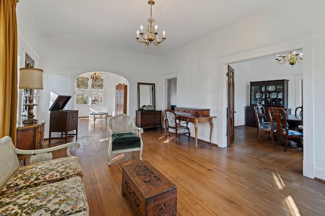 living room featuring hardwood / wood-style flooring, a notable chandelier, and ornamental molding