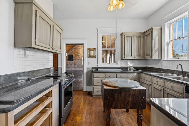 kitchen with stainless steel electric range, sink, decorative backsplash, decorative light fixtures, and dark hardwood / wood-style flooring