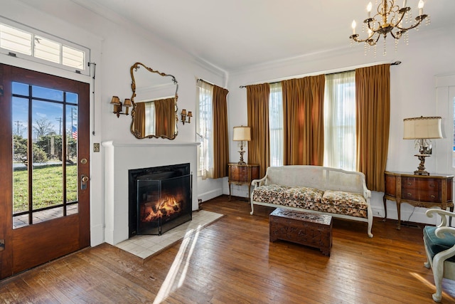 living room featuring an inviting chandelier, a healthy amount of sunlight, and wood-type flooring