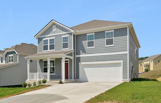 view of front facade featuring a porch, a garage, and a front yard