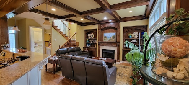 living room featuring hardwood / wood-style floors, beam ceiling, coffered ceiling, and plenty of natural light