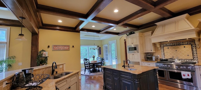 kitchen with light stone counters, stainless steel appliances, light hardwood / wood-style floors, tasteful backsplash, and sink