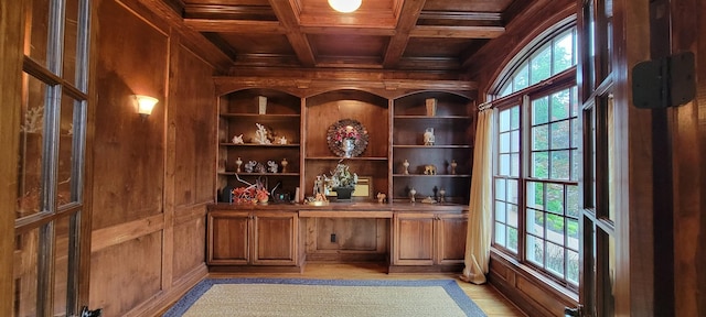 wine room with built in desk, coffered ceiling, wooden ceiling, and wood walls