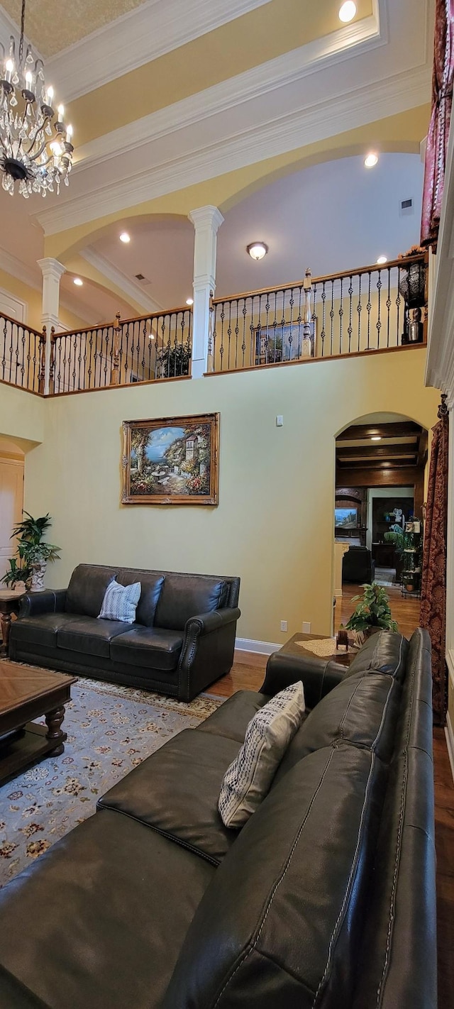 living room featuring hardwood / wood-style floors, an inviting chandelier, and ornamental molding