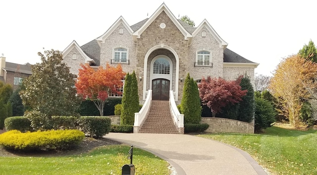 french country home featuring a front lawn