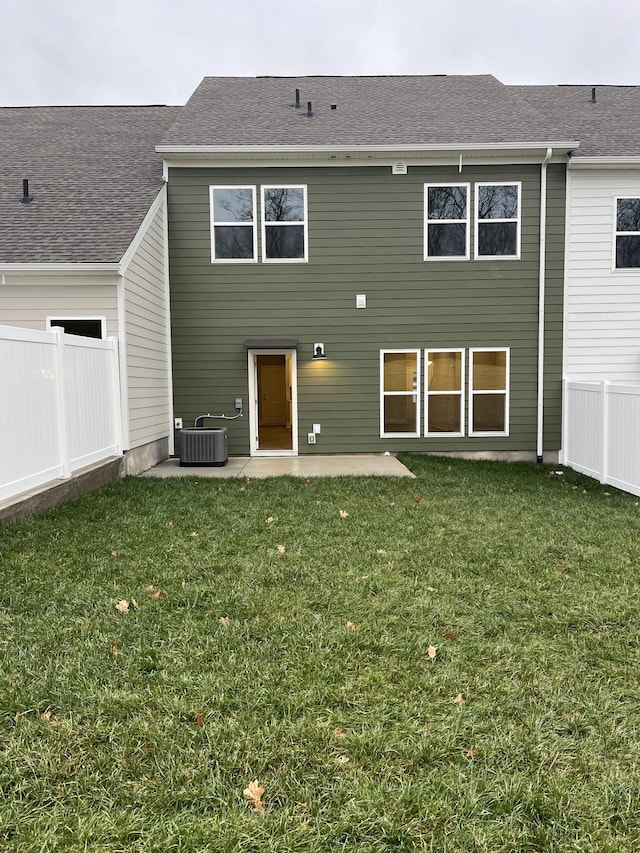 rear view of house featuring a yard, central AC unit, and a patio area