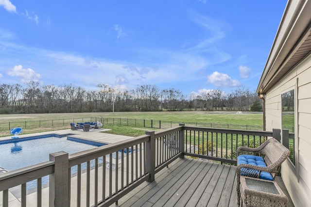 wooden deck with a rural view, a fenced in pool, and a yard