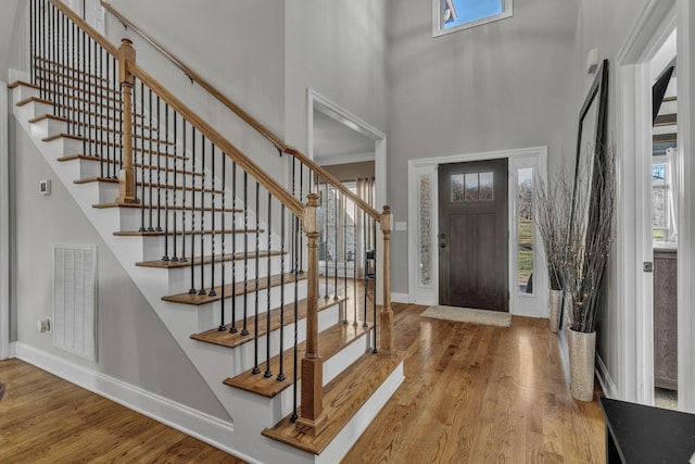 foyer entrance featuring a high ceiling and light wood-type flooring