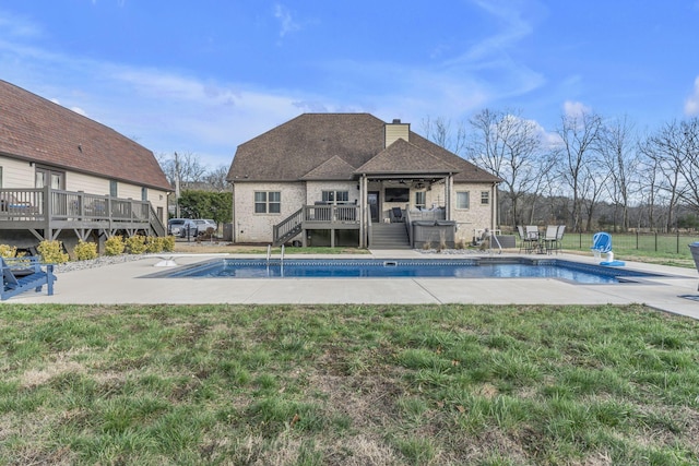 view of swimming pool featuring a lawn, a patio area, and a wooden deck